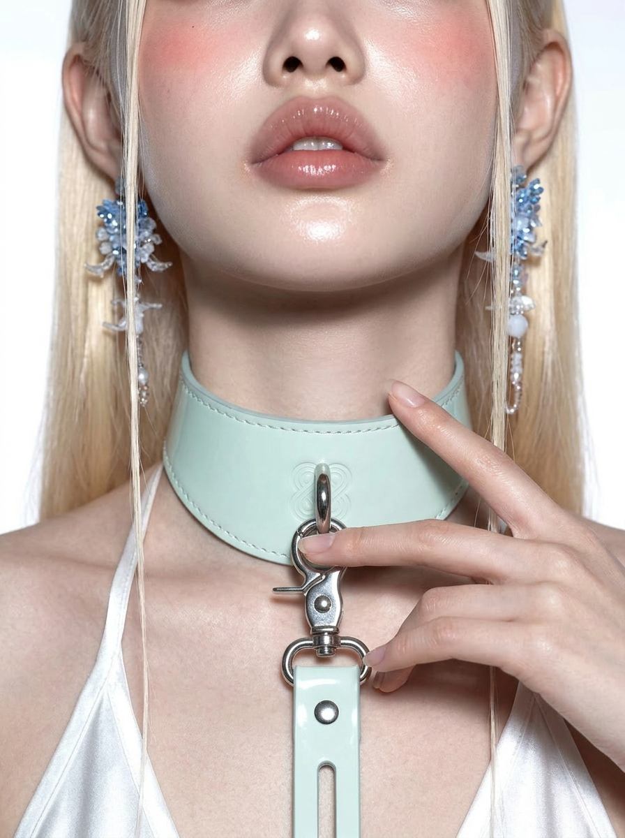 Close-up of a person wearing a light blue leather choker with a keychain attachment.