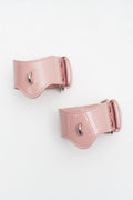 KINETIC PULSE: Kinetic Rose pink patent leather handcuffs designed as architectural wrist braces